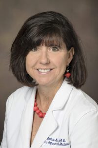 Headshot of Monica Kraft, MD, in a white coat.